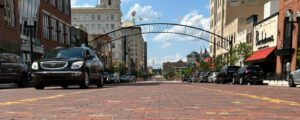 Street level view of Saginaw Street from the center of the roadway, looking northward. The arches over the street and the weatherball can been seen.