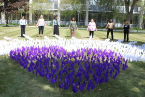 Members of the Public Health Office standing behind a flag emplacement in the shape of a heart for National Overdose Awareness Day