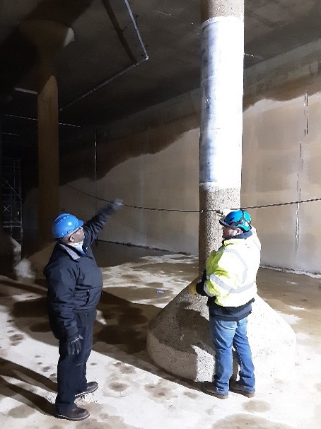 City Administrator Clyde Edwards and a construction contractor inspect the inside of a reservoir empty of water in order to make repairs and upgrades.