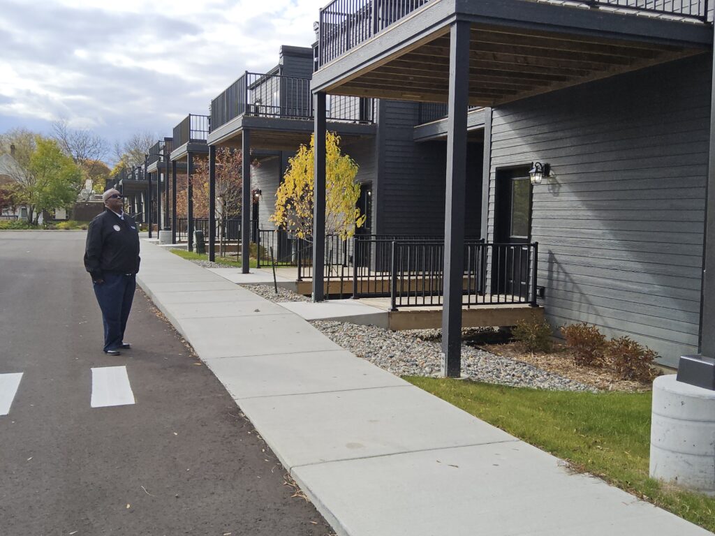 Clyde Edwards standing outside of a newly built housing unit