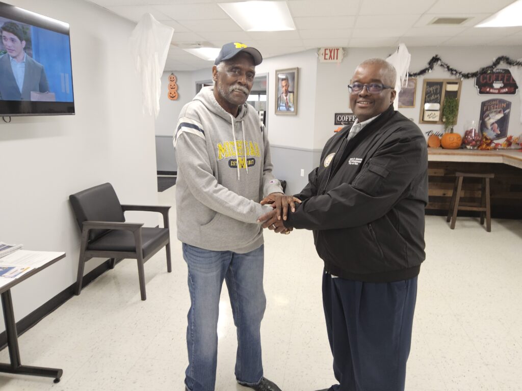 Clyde Edwards shaking hands with a senior at the Mays Center