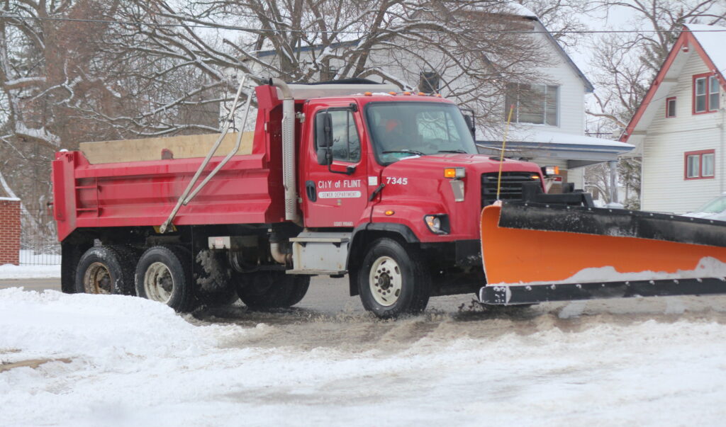 A City plow truck plowing snow from the street