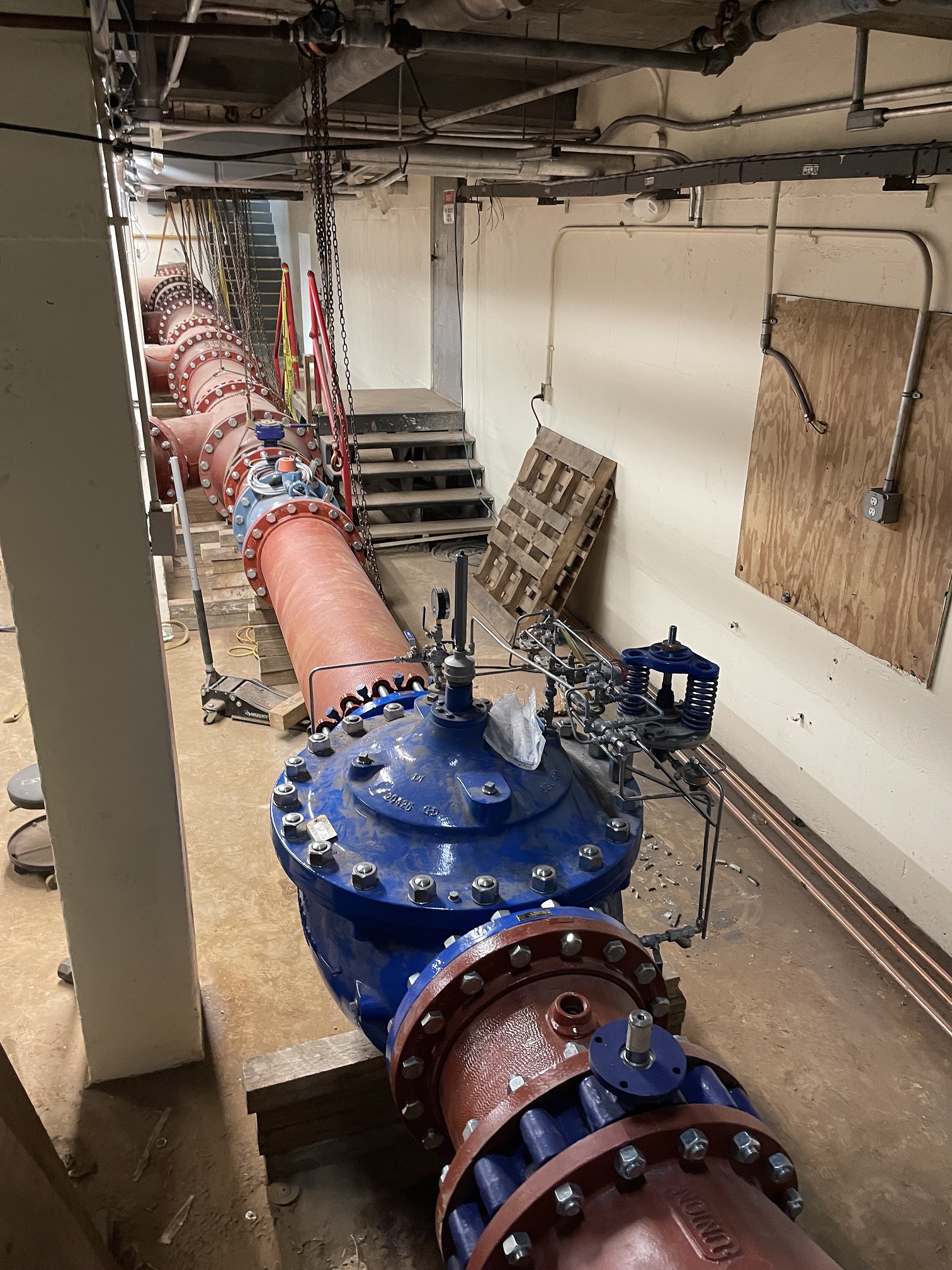 A large water pipe connected to a valve inside a building.