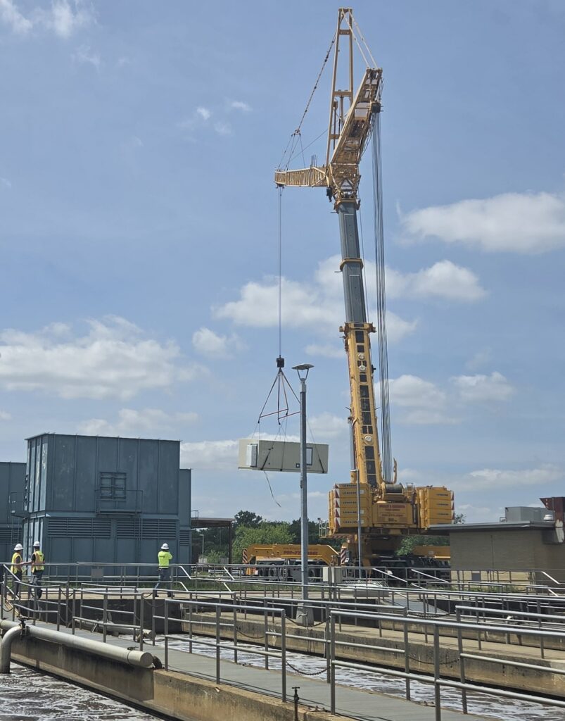 Innovation after two decades: a large crane lifts a new section of equipment to be placed at that Water Pollution Control plant.