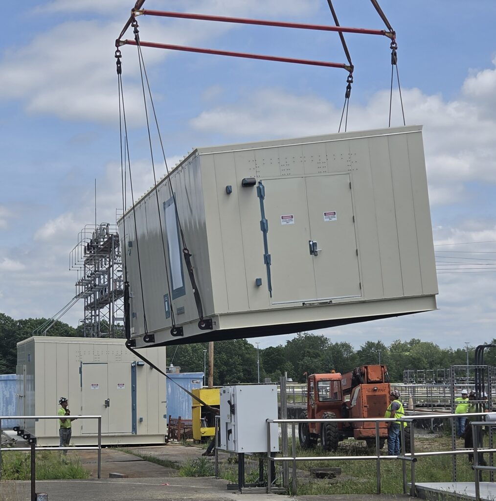 Power supplying innovation: a close-up view of a power supply unit being lifted into place at the Water Pollution Control plant.