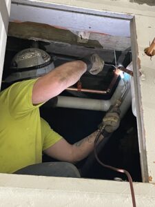 A worker welding a piece of pipe inside the Cedar Street Pump Station.