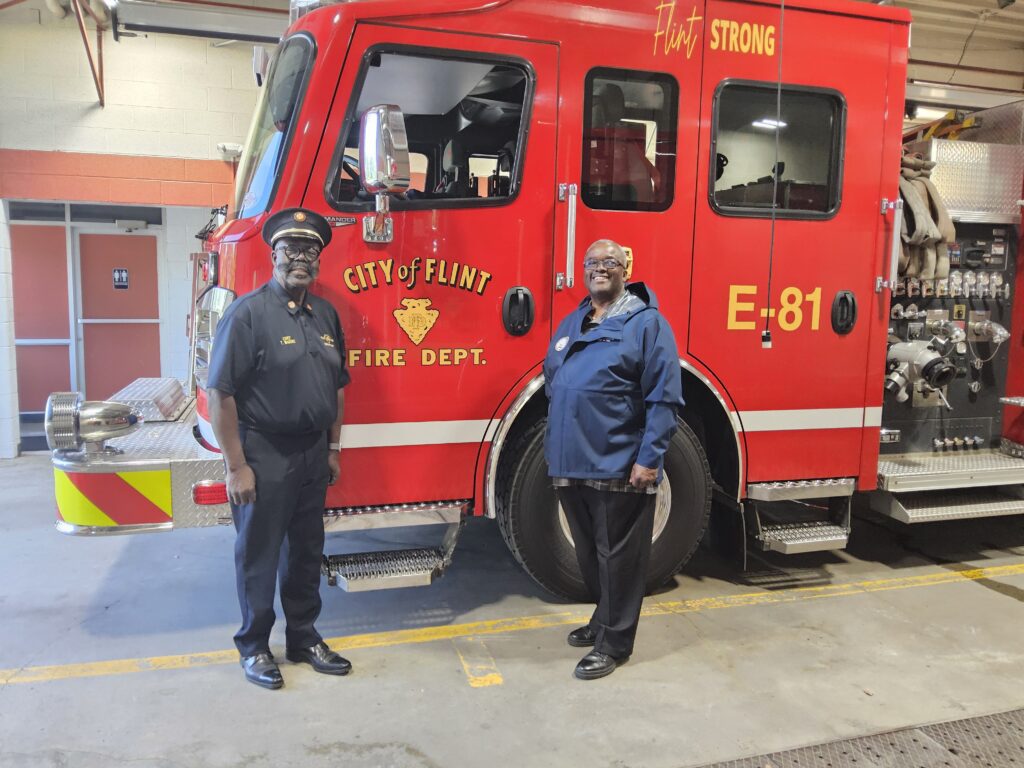 (From left) Fire Chief Theron Wiggins and City Administrator Clyde Edwards standing in front of a new Flint Fire Department truck inside the garage of Flint Fire Station #1.